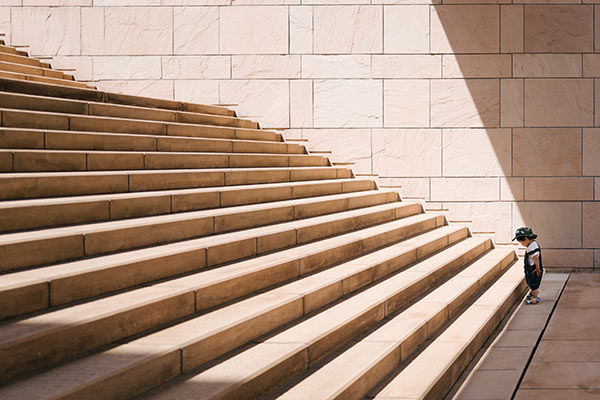 Small child at the base of a large set of stairs