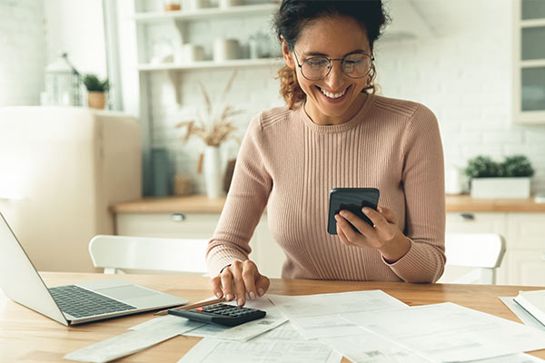 Woman using a calculator and a smart phone