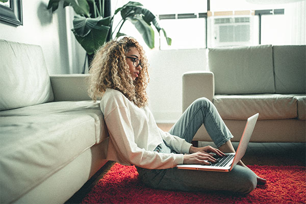 Woman sitting on the floor using a laptop