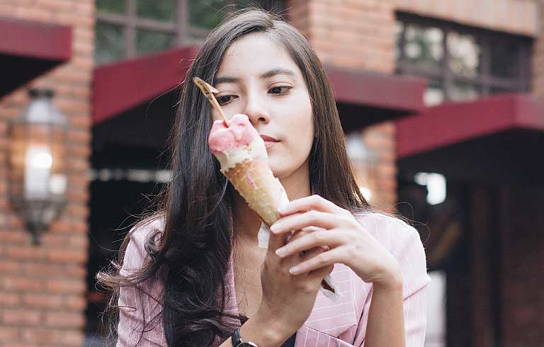 Woman eating a melting ice cream cone