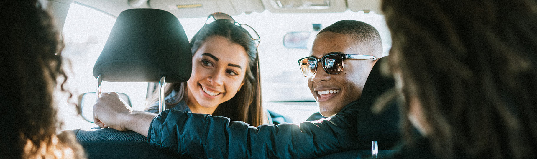 guy and girl in a car looking back at passengers