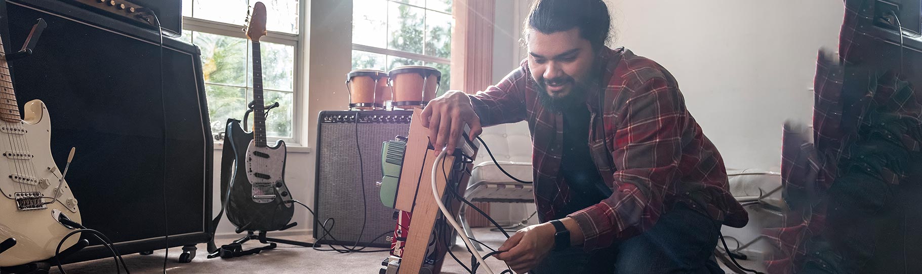 man hooking up his guitar cables