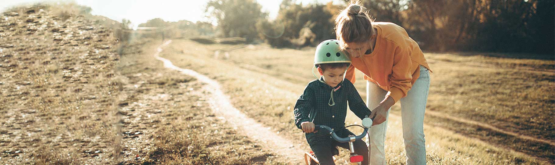 mom teaching her son how to ride a bike