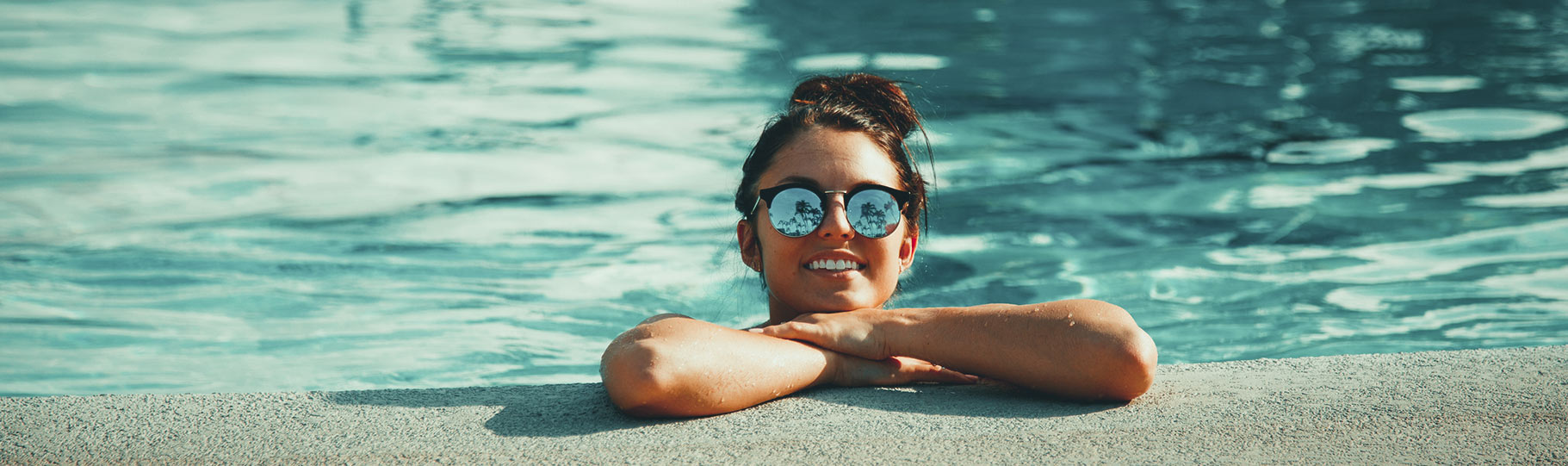 woman leaning on the edge of a swimming pool