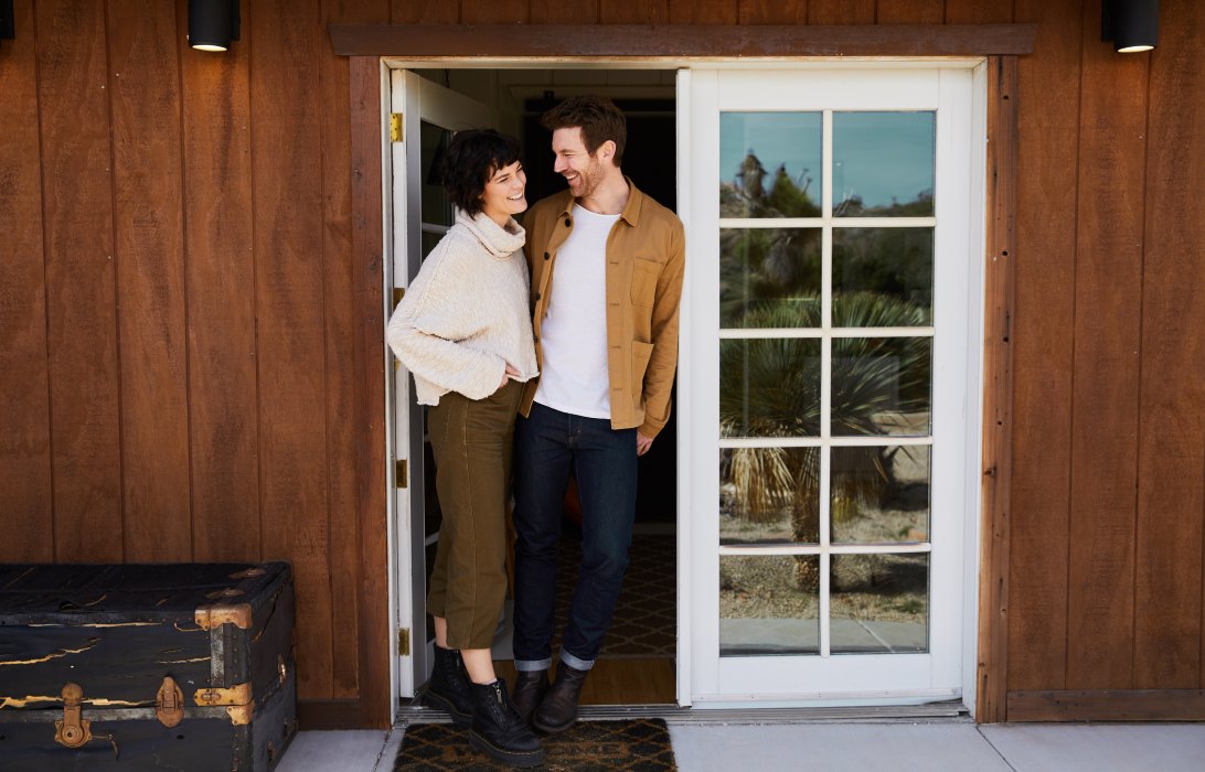 young couple standing outside their new home