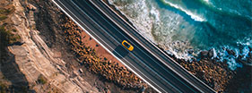 Yellow car driving along the coast