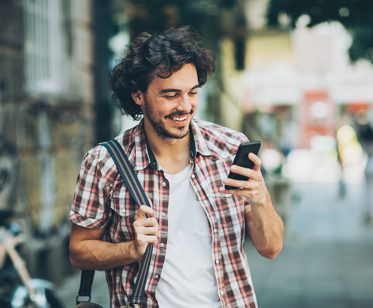 man walking while on his phone outside