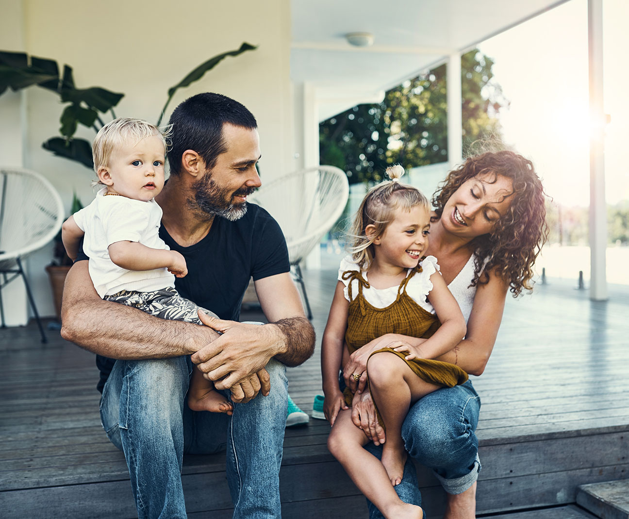 mom and dad sitting on the porch with their two kids