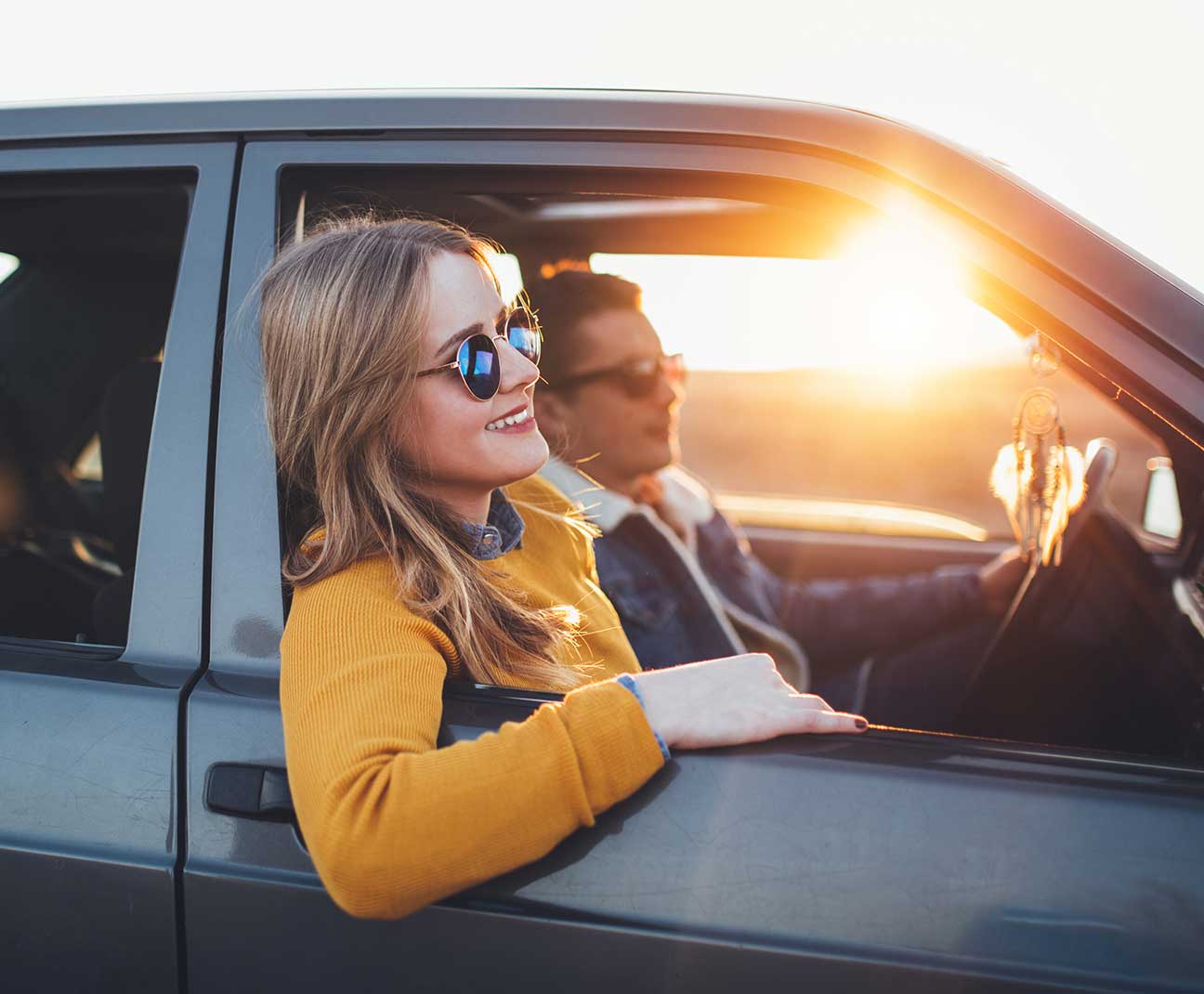 Couple driving in car at sunset