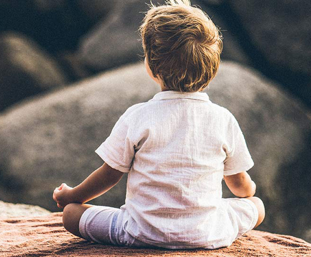 kid meditating on a rock