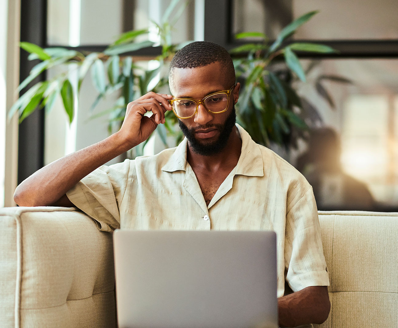 young man working on his laptop from the couch