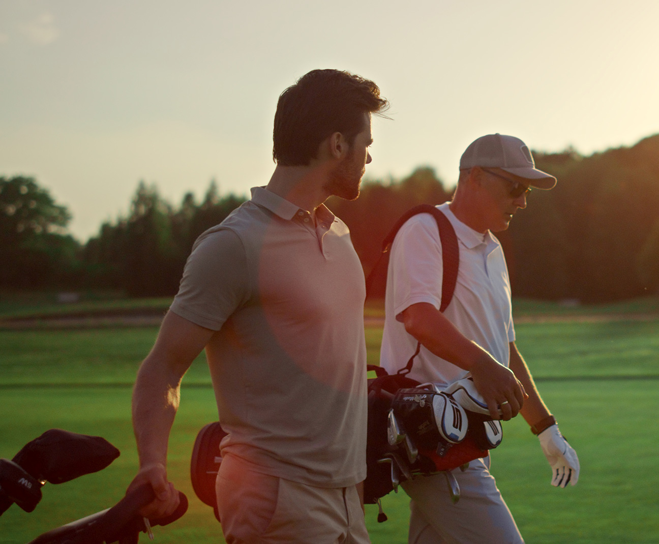 two men golfing at sundown