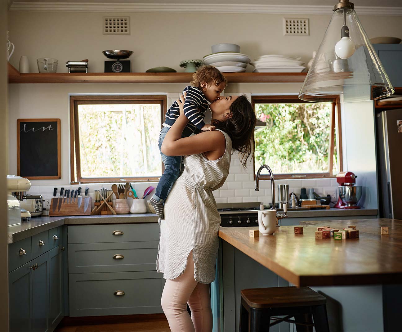 mother holding son in kitchen