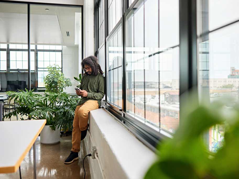 Young entrepreneur sitting on windowsill.