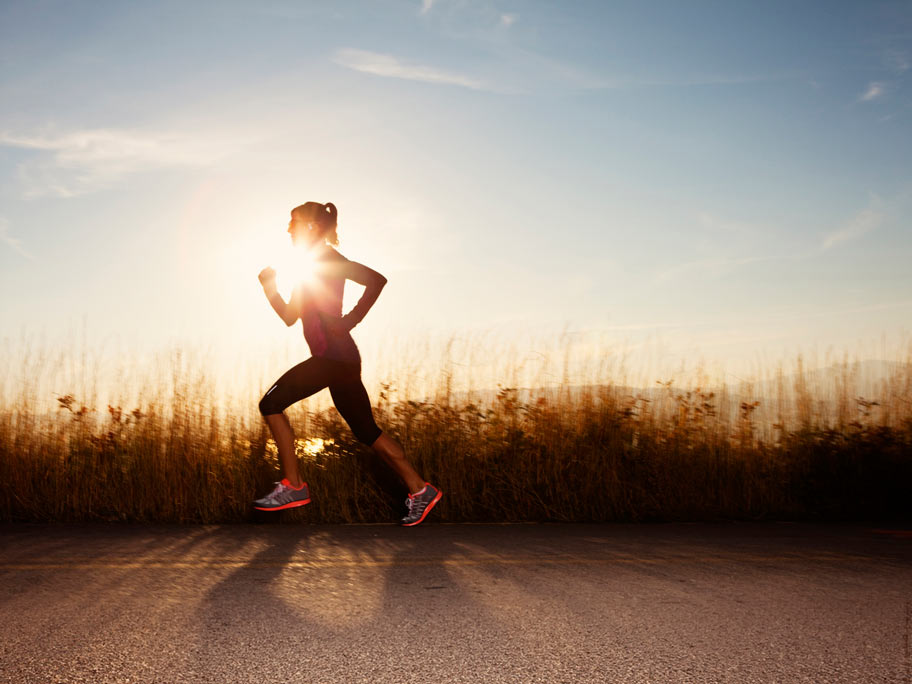 Woman running at sunset.