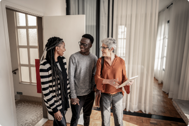 A young couple tours a home with their realtor.