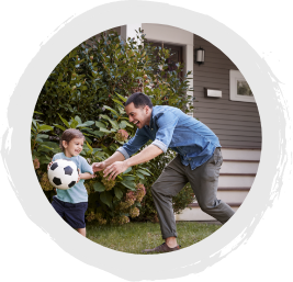 A father and son playing soccer.