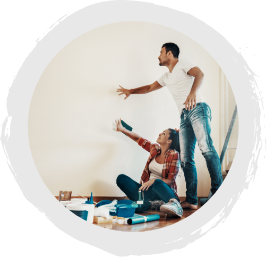 A young couple painting the walls of their new home.