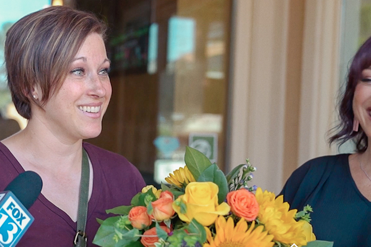 woman holding flowers and doing an interview