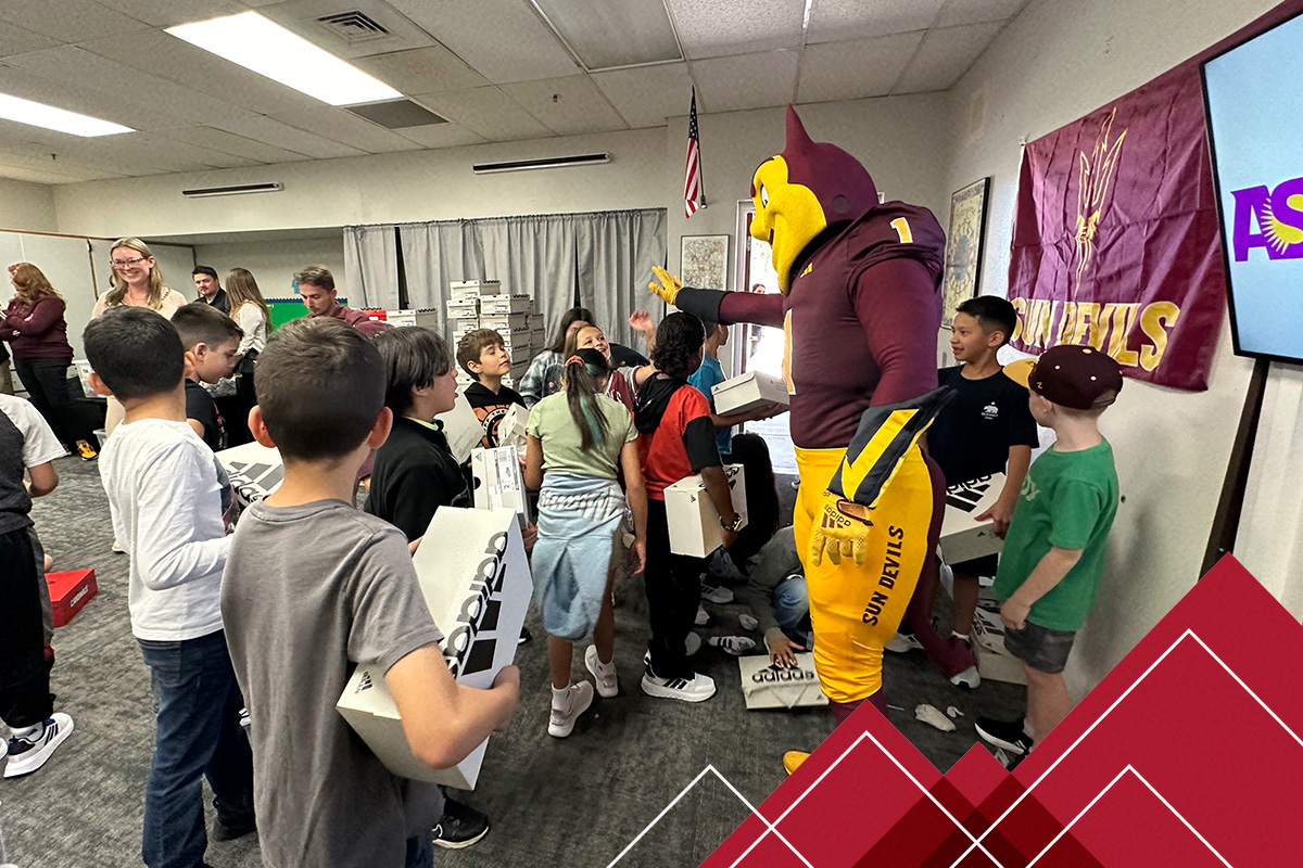 Sparky the Sun Devil helps distribute over 300 pairs of shoes to students