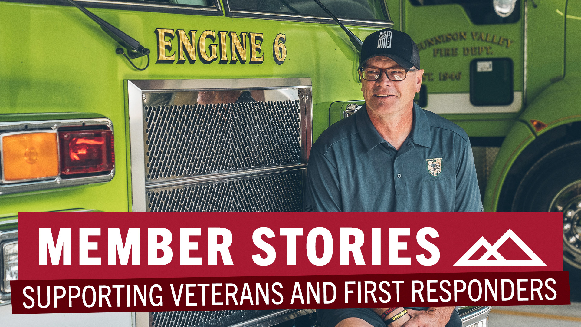 man in glasses and baseball cap sitting on bumper of fire engine