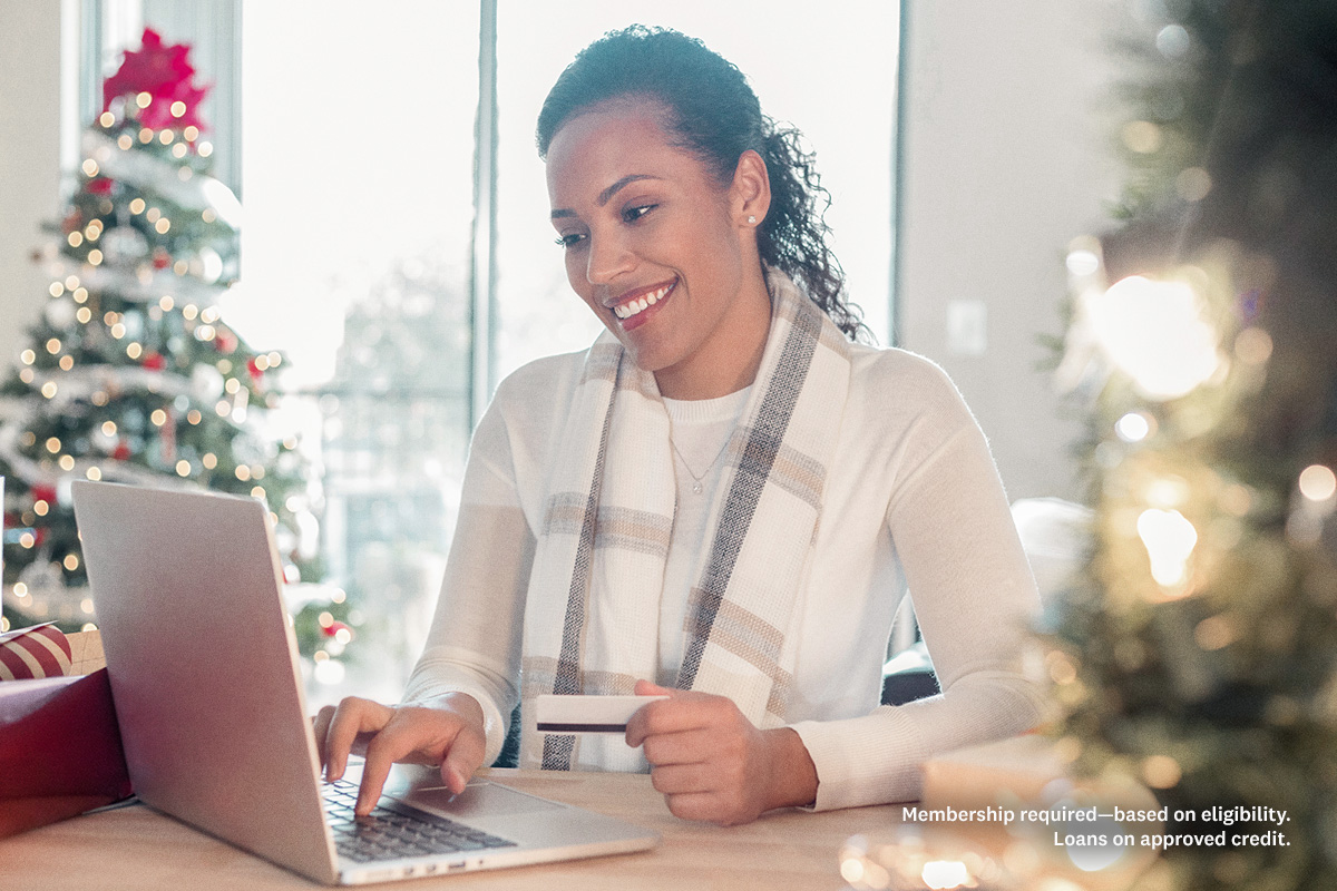 woman on the computer in front of christmas tree
