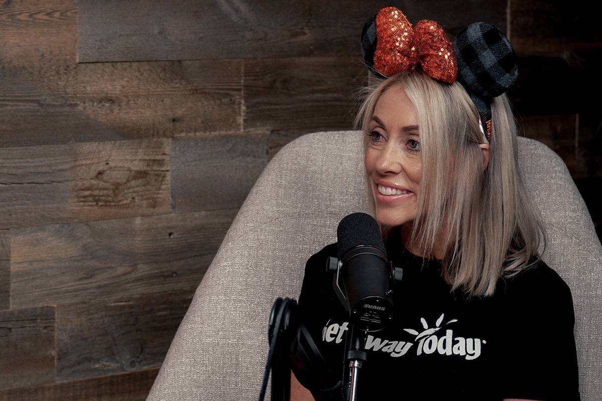 blonde lady with Halloween mouse ears sitting in front of podcast mic