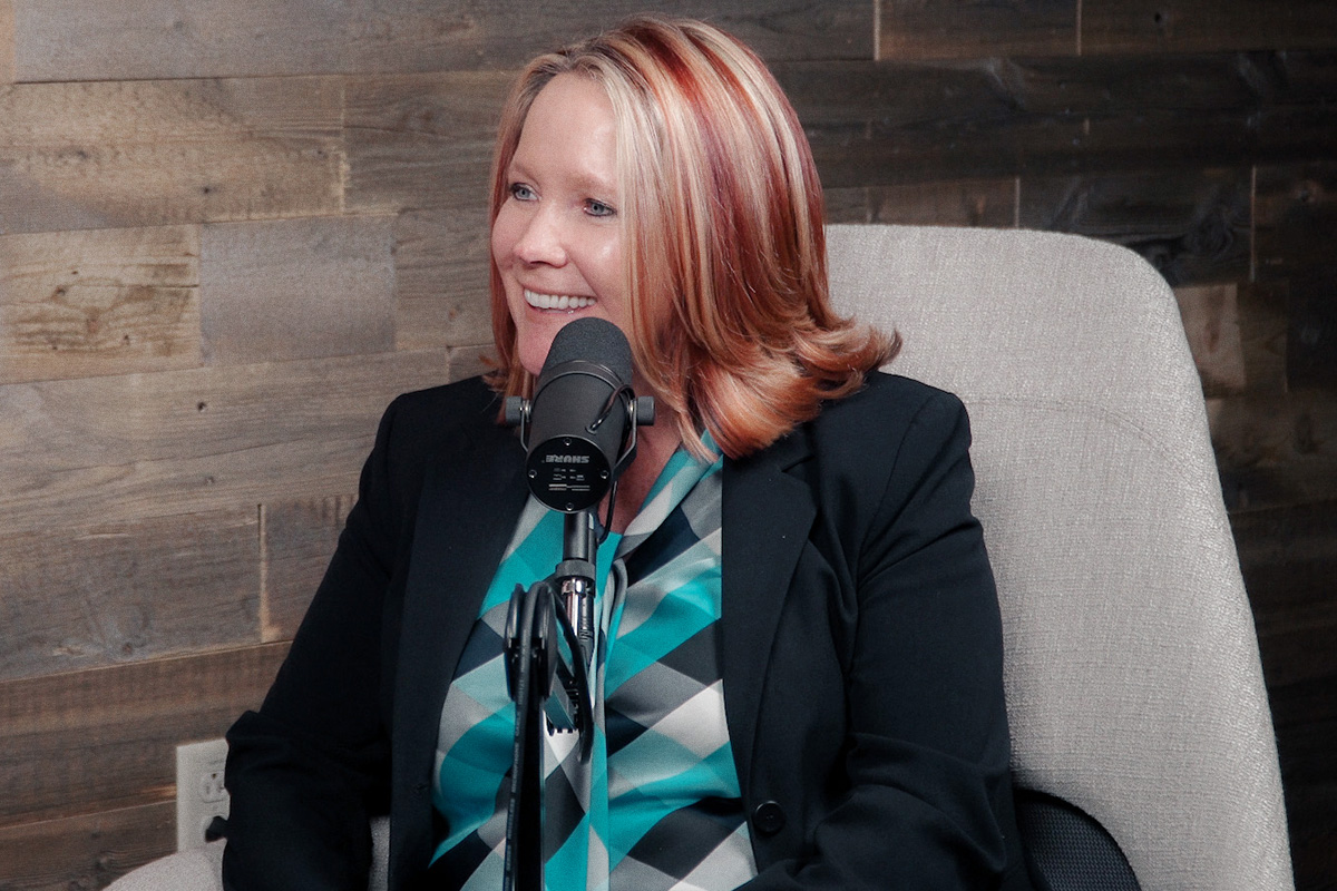 Woman in black blazer in front of podcast mic