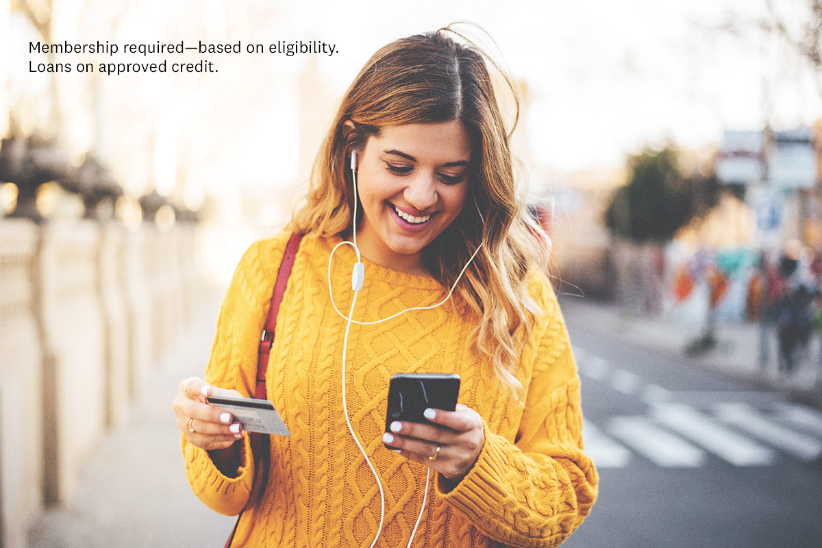 women on her phone holding card