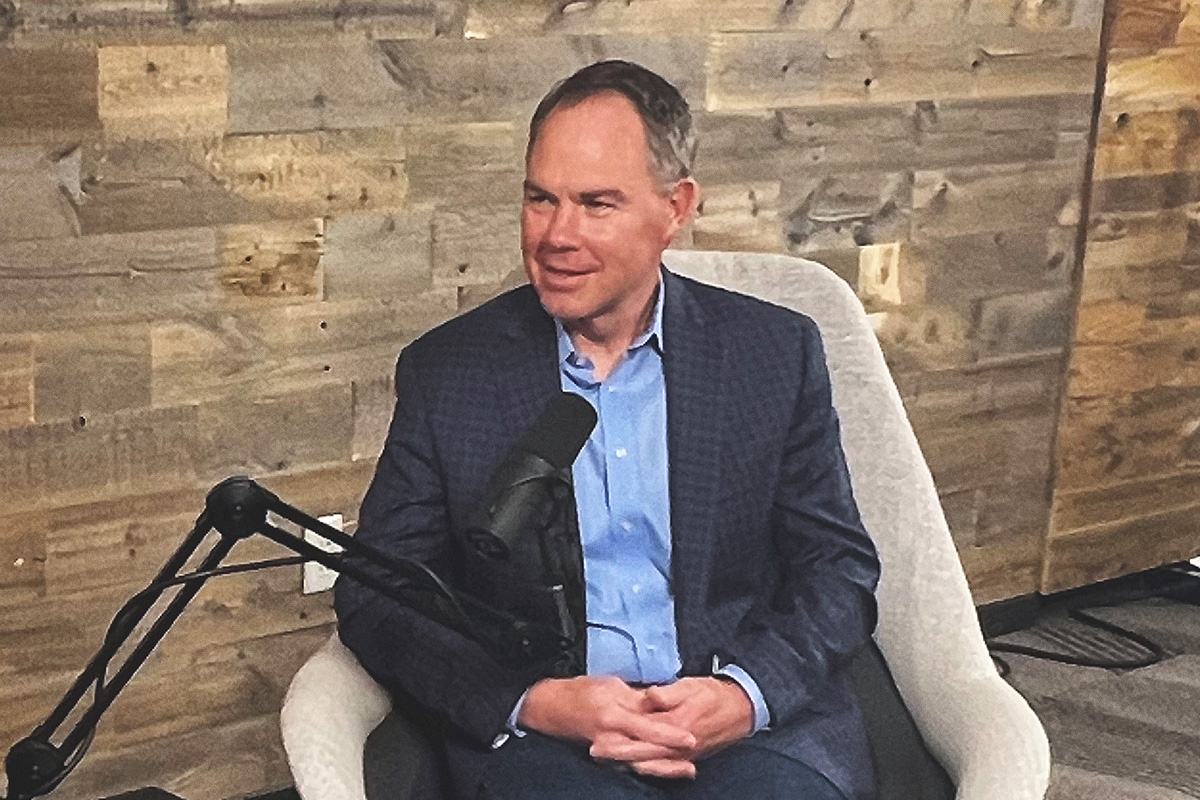 man in blue suit and shirt at podcast mic