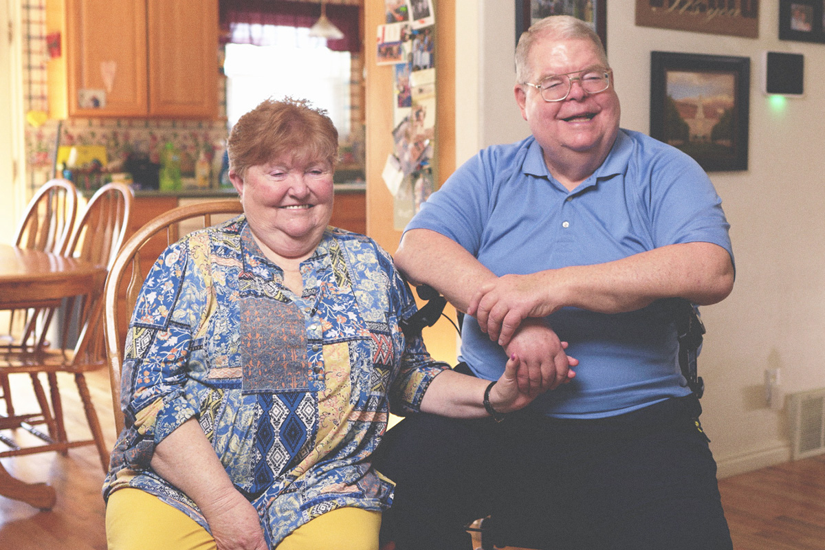 elderly couple sitting next to each other and smiling