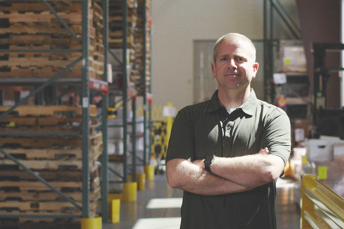 man standing in warehouse with arms crossed