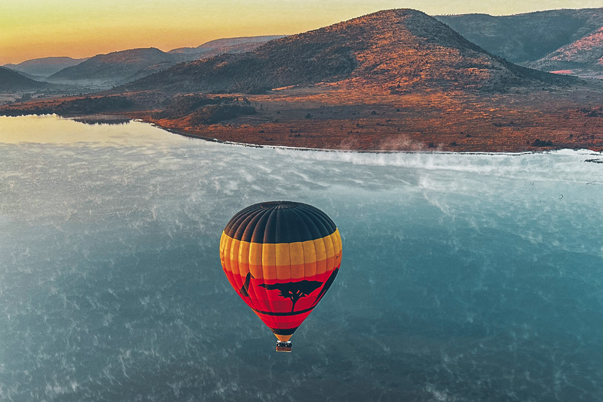 Hot air balloon in the air over lake