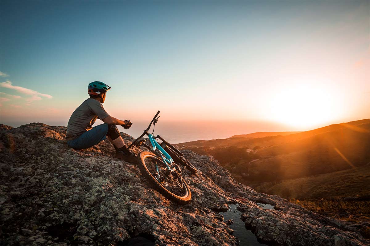 Woman with bicycle at mountain top