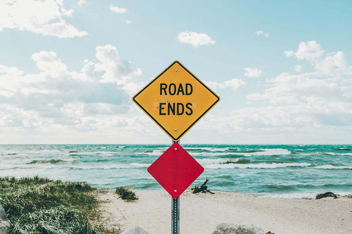 yellow "road ends" sign on the beach