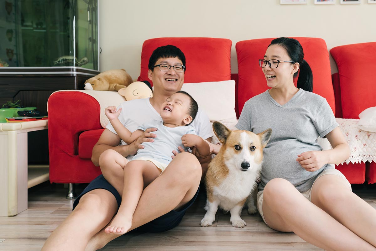 parents laughing with their kid and dog