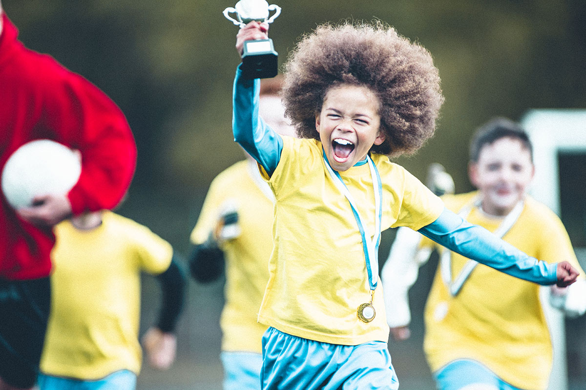 boy celebrating with a trophy in his hand