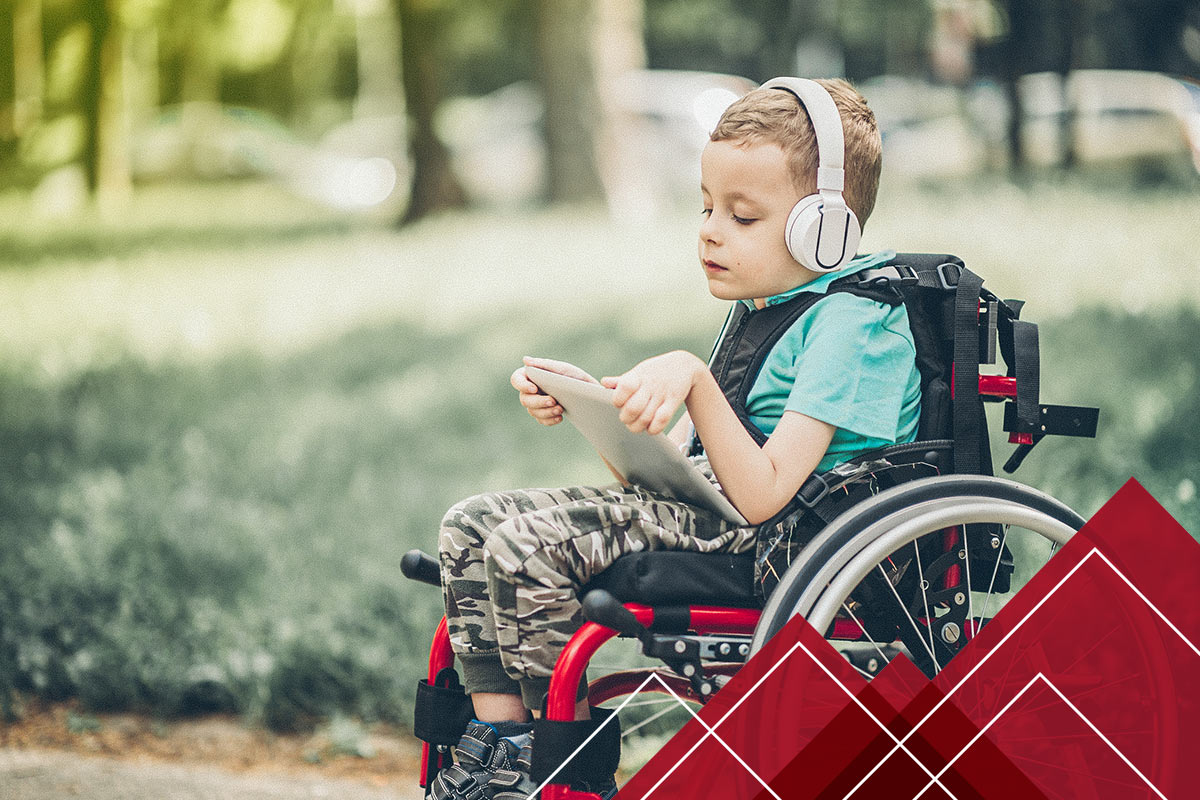 little boy on a tablet in a wheelchair