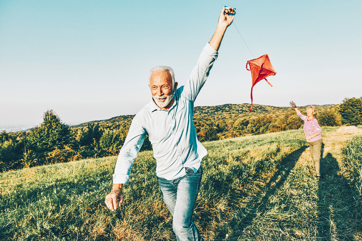 old couple flying a kite in a field