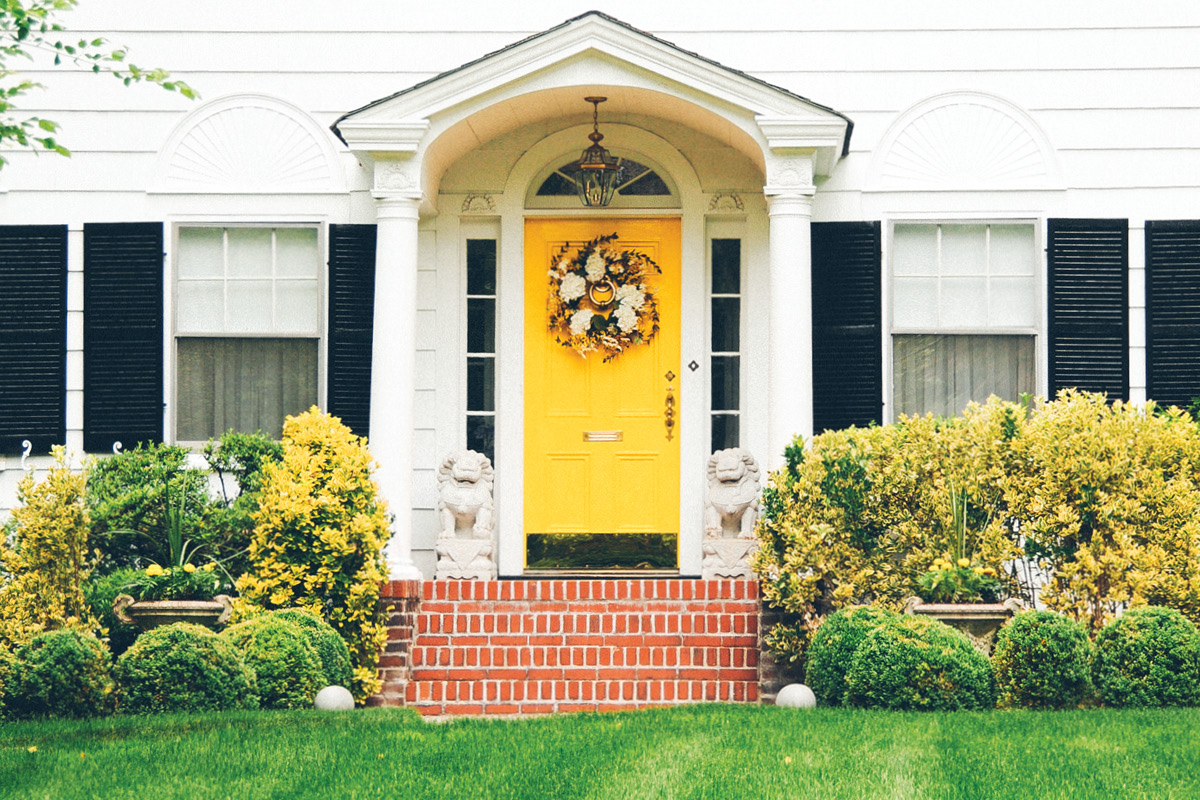 the front of a house with a yellow door