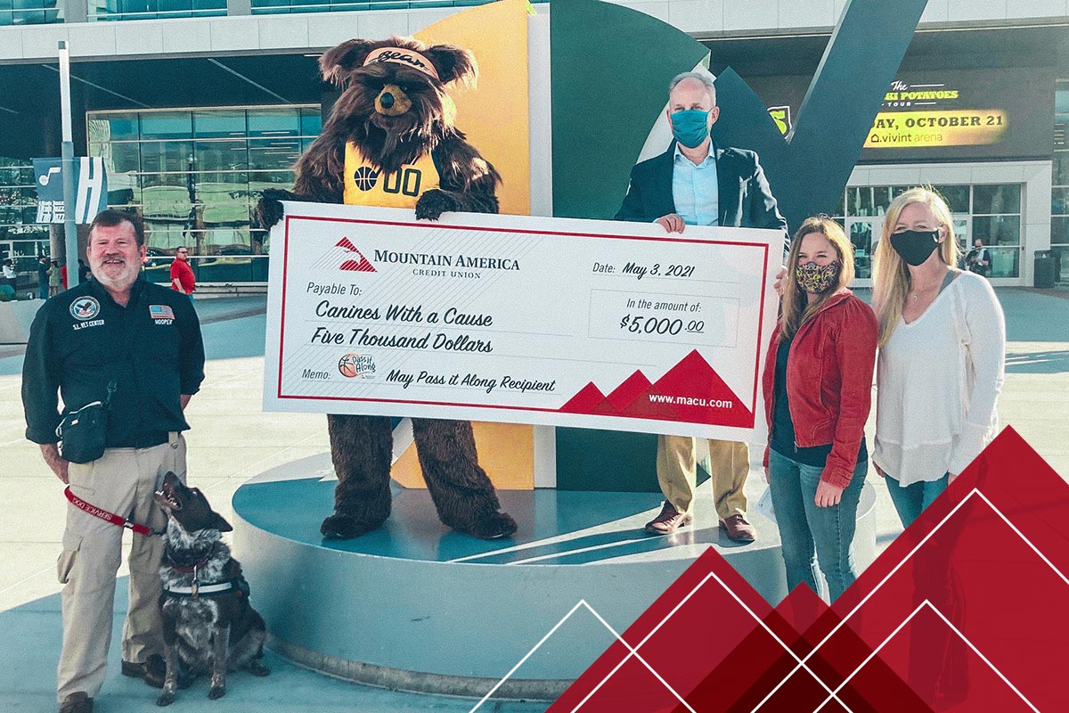Utah Jazz mascot holding a donation check for Canines With a Cause