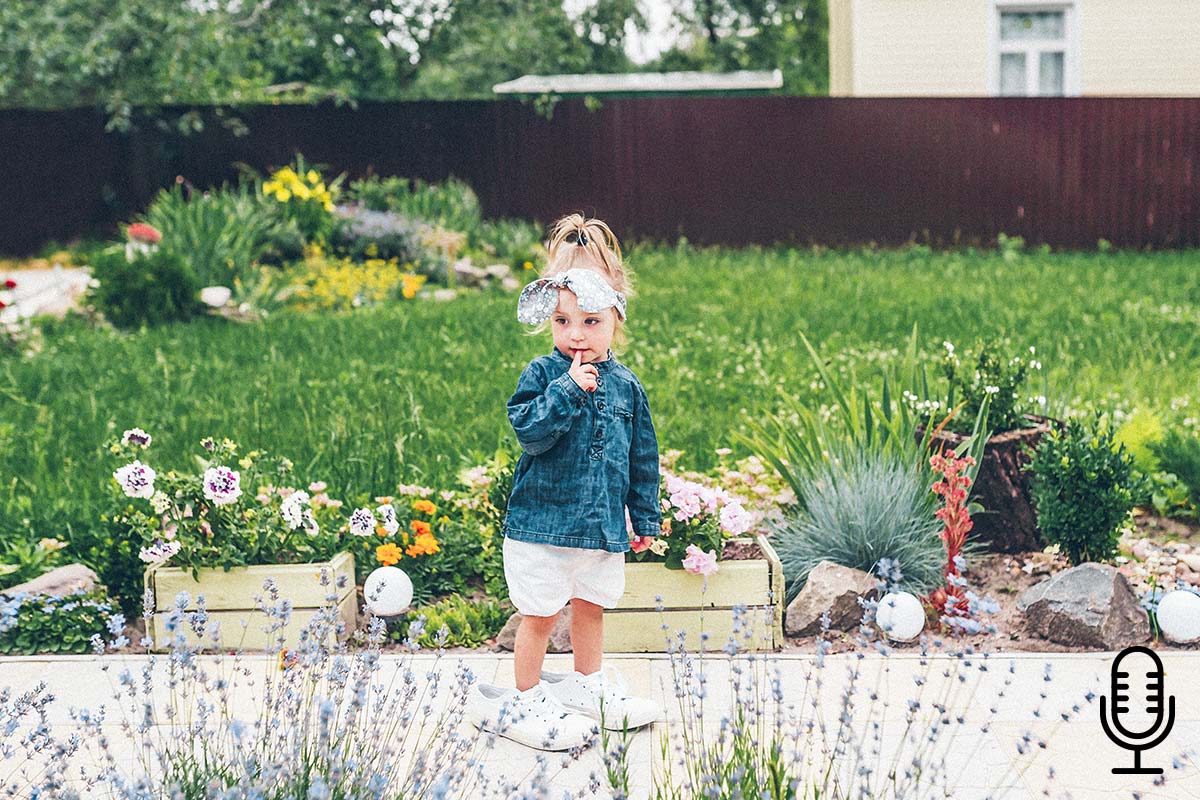 little girl outside looking at flowers
