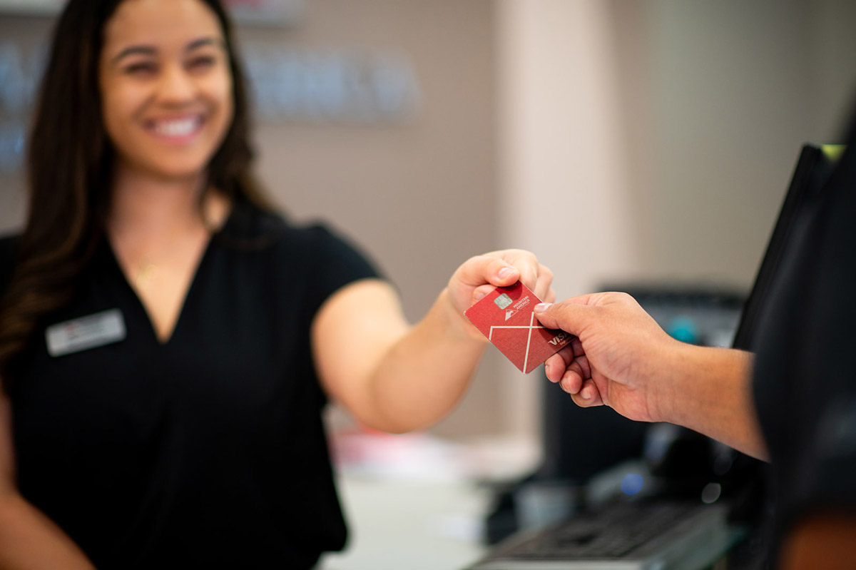 employee handing a credit card to a member