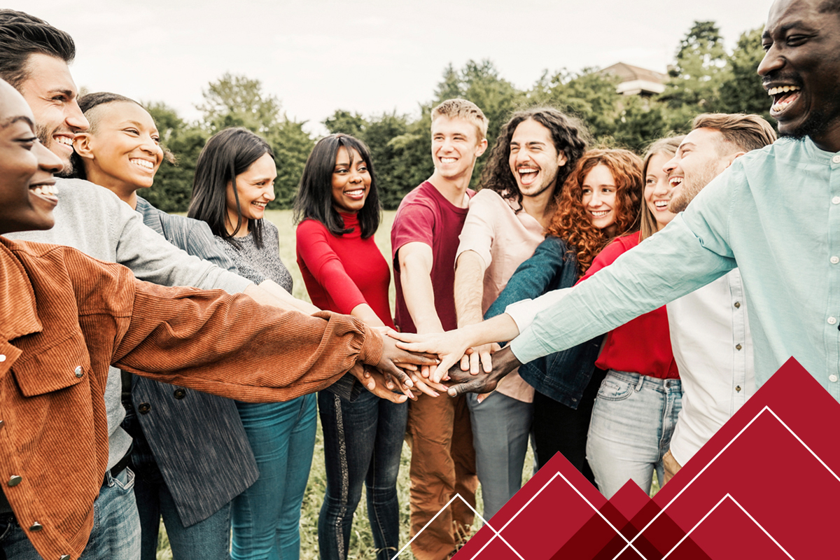 group of people in a circle putting their hands on top of another