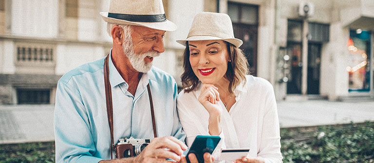 elderly couple making purchase on phone