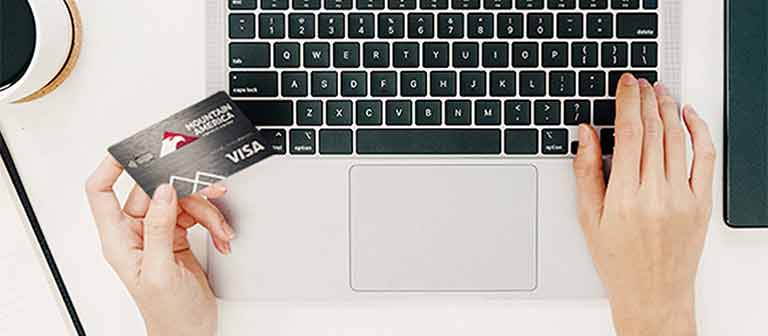 Person using credit card on computer