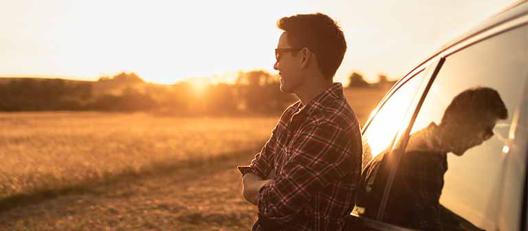 Man standing by his car